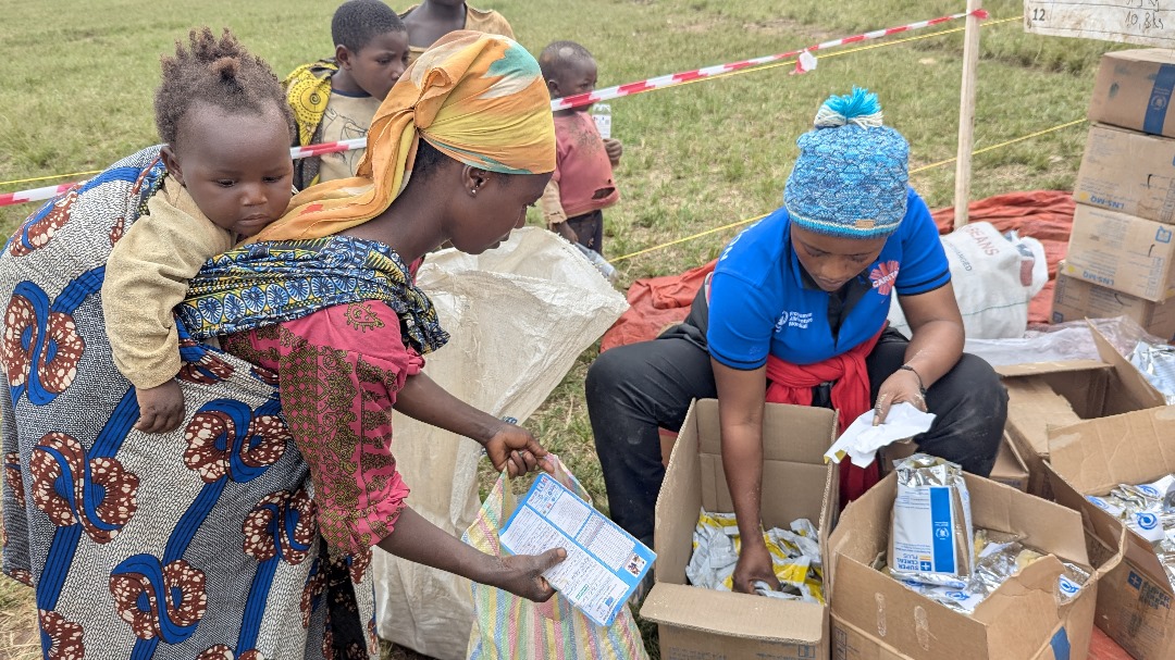 Distribution des instants nutritionnels à une femme allaitante et déplacée de guerre en zone de santé de Musienene. Kimbulu, le 10 juillet 2025. ©Caritas Butembo-Beni/Elie MBULEGHETI