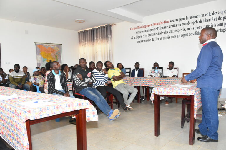 « Sur cette image mis en avant, Charles SABUNI, Chargé de Suivi et Évaluation à CARITAS Développement Butembo-Beni, échange avec les nouvelles recrues lors d’une séance d’immersion et d’orientation organisée au siège de l’organisation. »